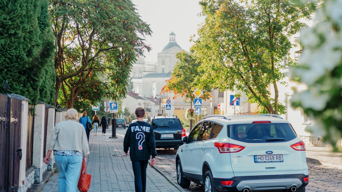 a couple of people walking down a sidewalk