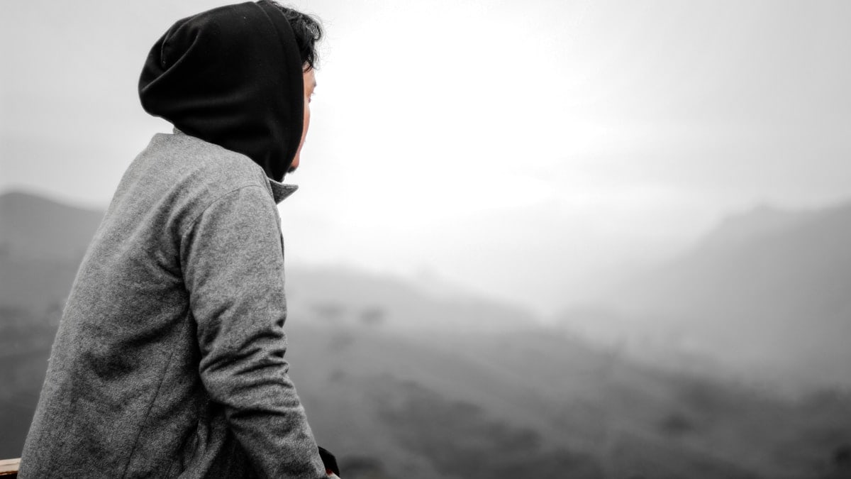 A person in a hoodie standing on a hill